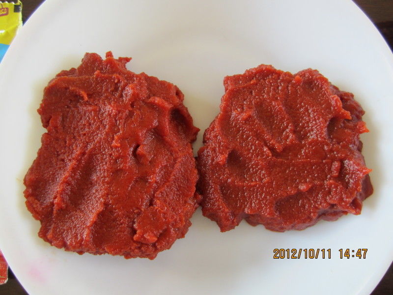 Pasta de tomate doce do volume triplo do concentrado no escaninho de madeira nenhuns aditivos
